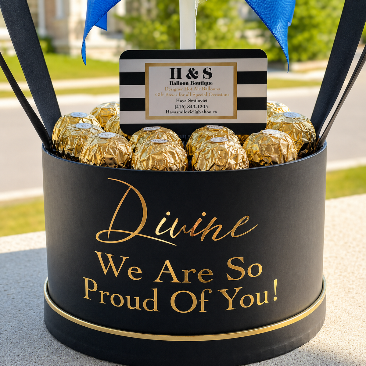 Close-up of a personalised graduation gift box for Divine featuring gold-wrapped chocolates, black and gold detailing, and a proud graduation message.