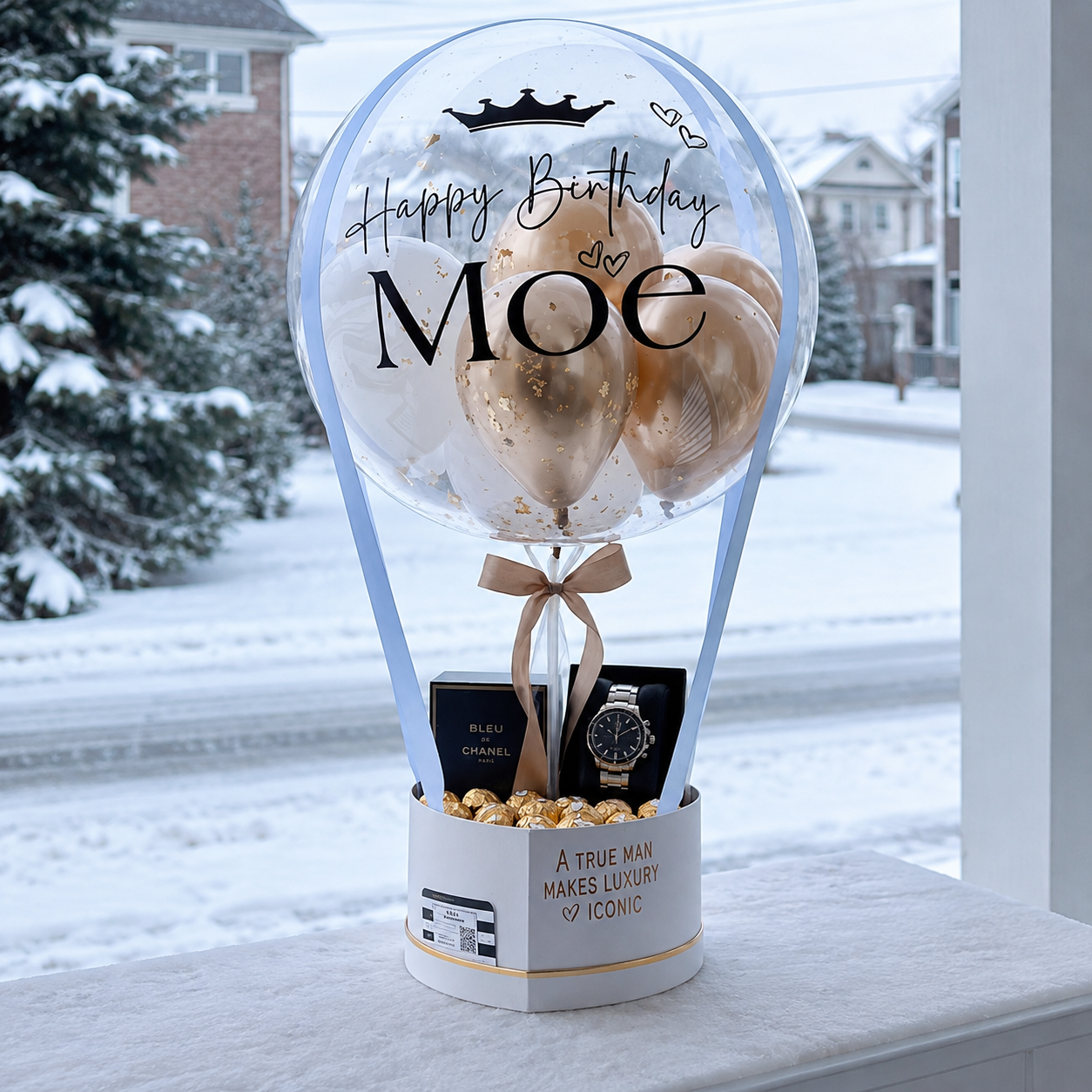 Moe’s birthday gift arrangement featuring a personalised clear balloon, beige and white balloons, a luxury watch, cologne, chocolates, and elegant ribbon accents.