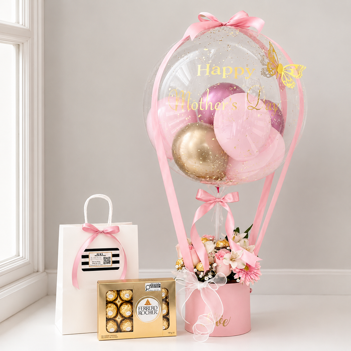 Mother’s Day gift arrangement featuring a personalised pink balloon, fresh flowers, Ferrero Rocher chocolates, ribbons, and a gift bag.