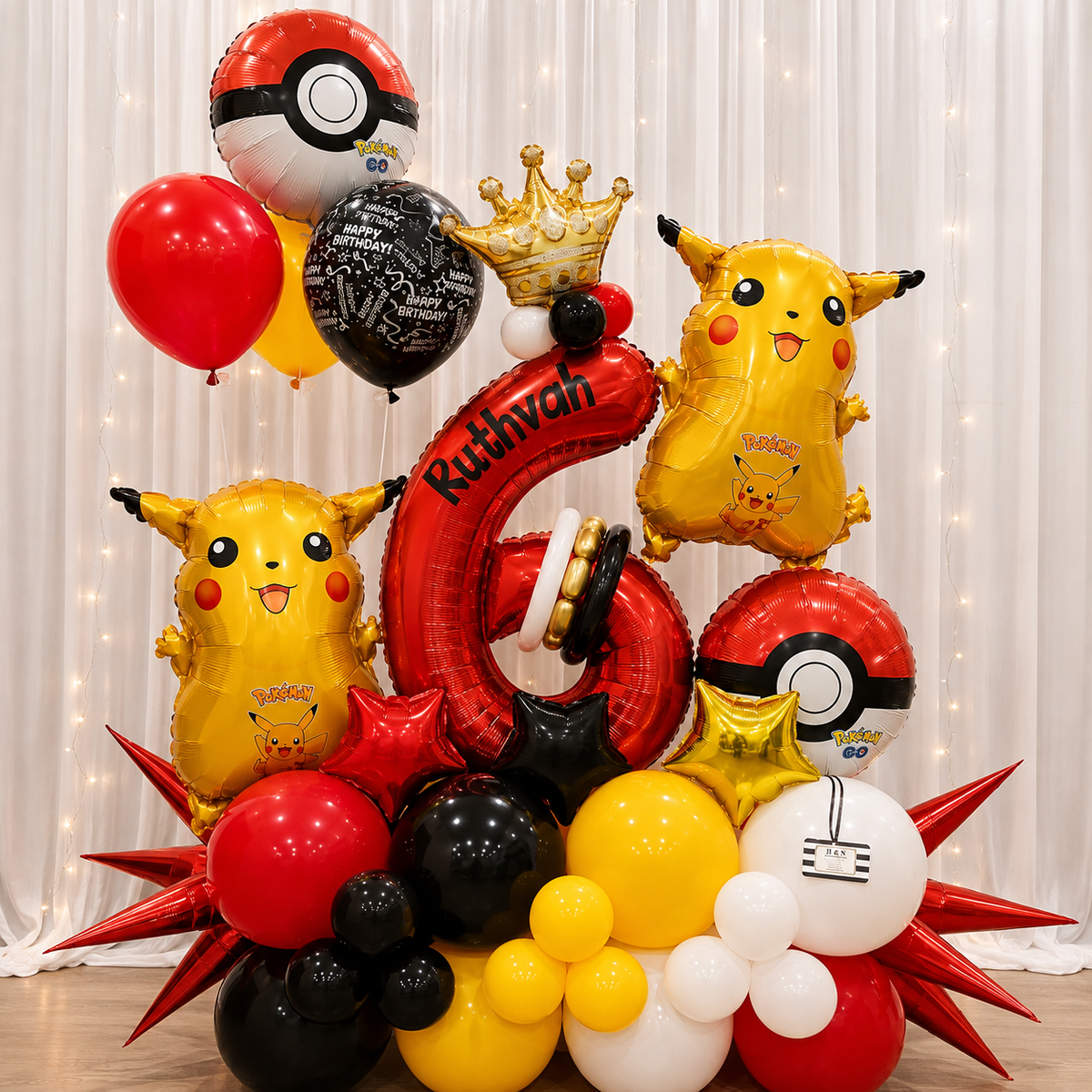 Pokémon themed 6th birthday balloon display featuring Pikachu and Poké Ball balloons, a large red number 6, red, yellow, black, and white balloon clusters, crown and star accents, and personalized birthday decor.