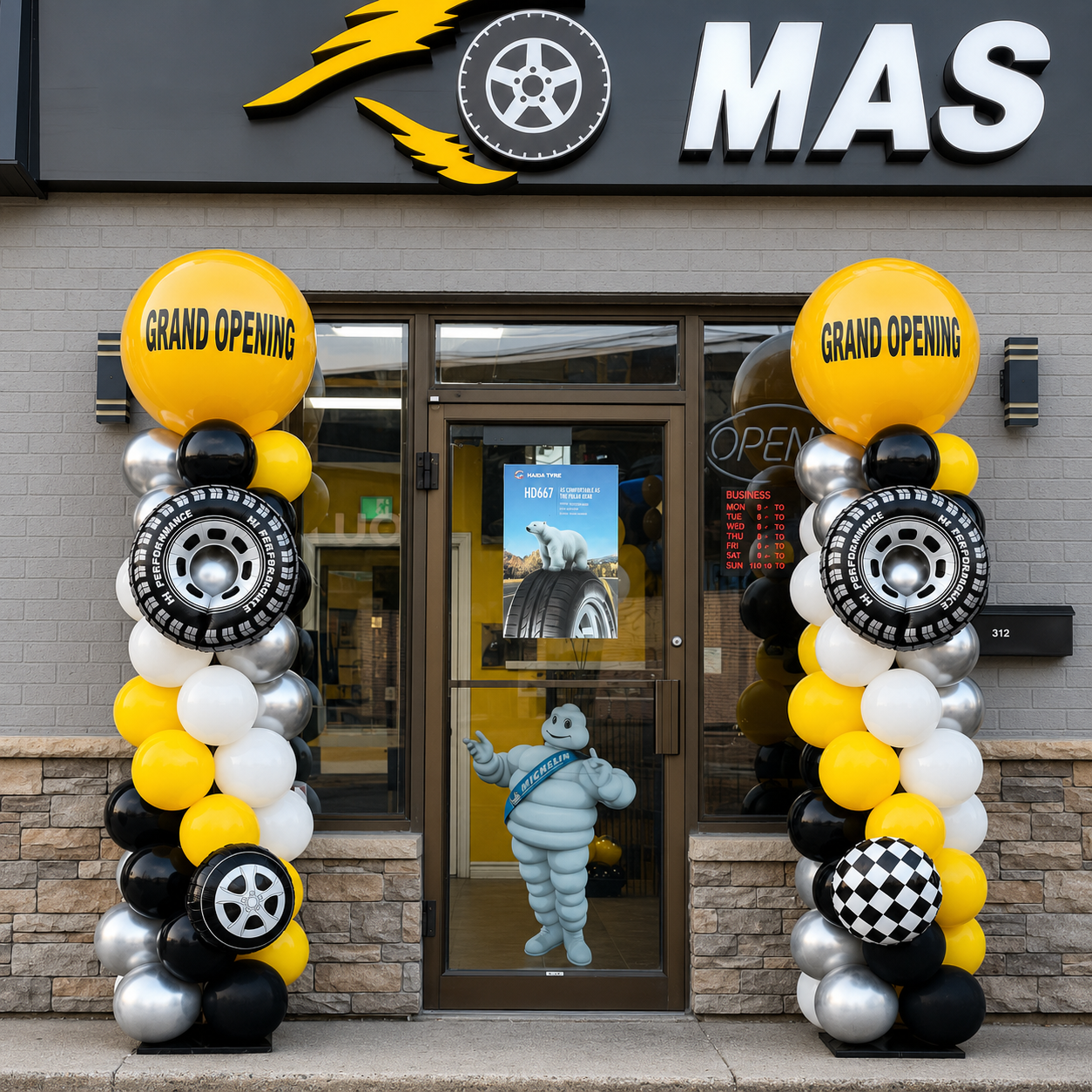 Masters Tire grand opening display featuring black, white, silver, and yellow balloons with tyre-shaped balloons and racing flags.