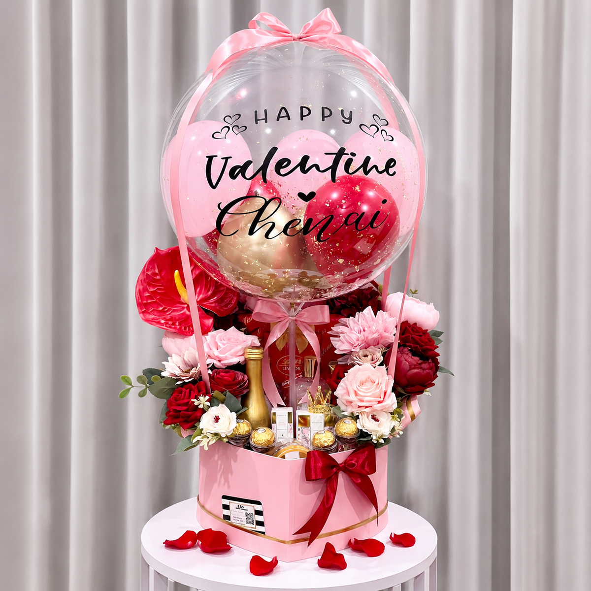 Valentine’s Day gift arrangement featuring a personalised clear balloon, pink and red balloons, red and pink flowers, chocolates, and elegant ribbon accents.